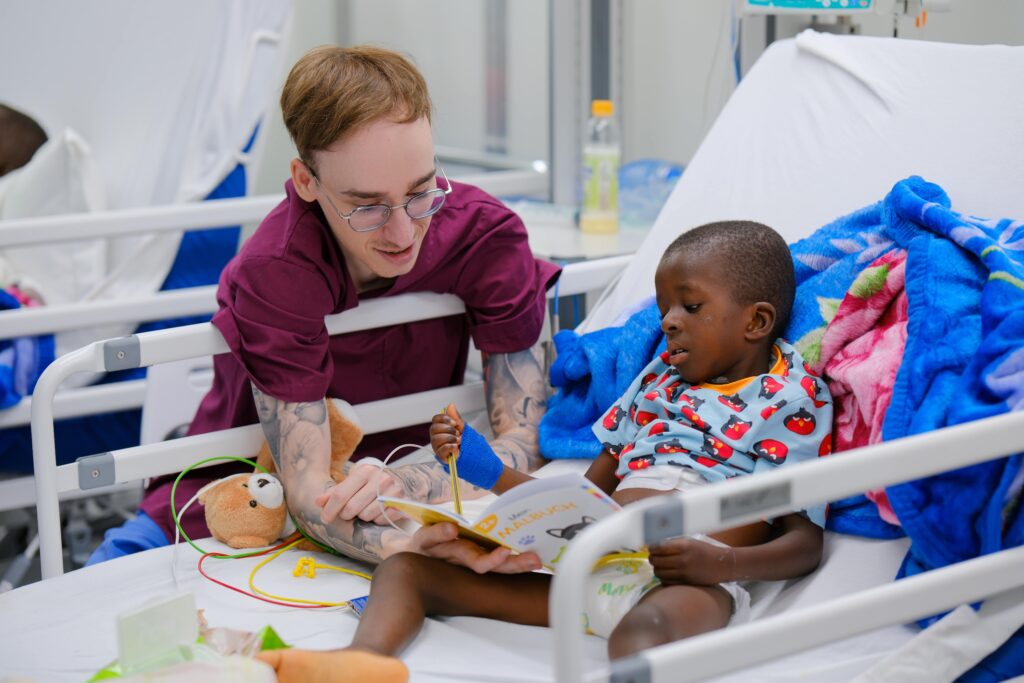 MOHKI-Burundi-2025-Pfleger-mit-Kind-ließt-buch